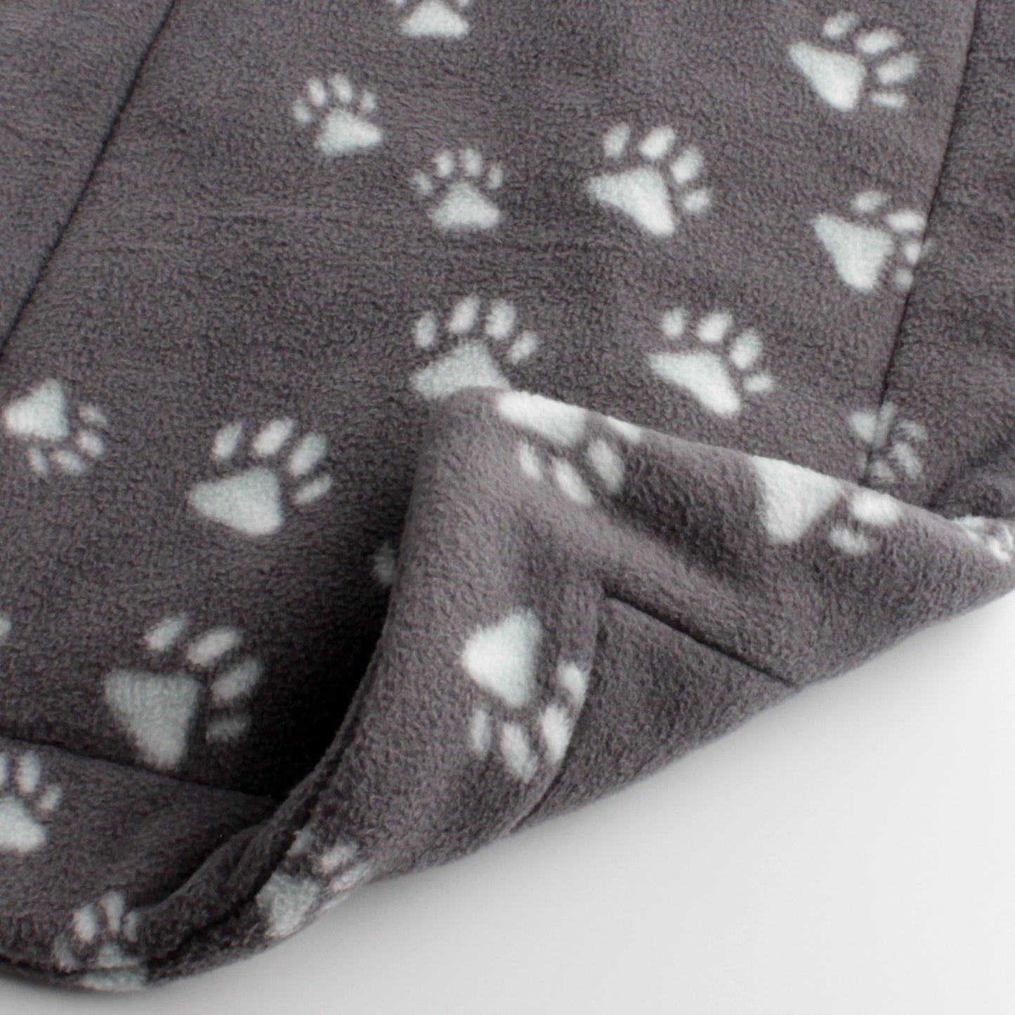 Closeup of grey cat mat with paw prints. The paw prints have a slight cyan tint to them. Front and back are the same.